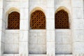 Texture of a brick wall and three wooden brown old seniors of an ancient carved Arab Islamic Islamic triangular window with orname Royalty Free Stock Photo