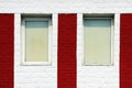 texture of bright red brick wall with white stripes and windows on a sunny day. Royalty Free Stock Photo