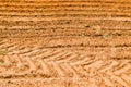 The texture of the brown earth of the sand road with traces of the tire treads of the tractor`s car tires. The background Royalty Free Stock Photo