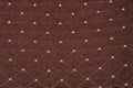 Texture of brown fabric with rombic pattern with white dot