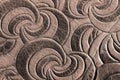 Texture of brown genuine leather close-up, with embossed spiral trend pattern. Fashionable background Royalty Free Stock Photo