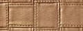 Texture of brown leather background with square pattern and stitch, macro. Abstract backdrop from bronze textile
