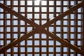 Texture of a brown wooden abstract lattice with square cells with holes from boards of log beams arranged vertically horizontally Royalty Free Stock Photo