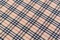 Texture of Burberry tartan fabric in beige, red and black at a slant. Background for your design October 26, 2023 in Kyiv, Ukraine