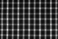 Texture of check fabric with white and black checks. Checkered black and white fabric background. Scottish tailoring material