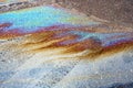 Texture of colorful petrol oil spill on wet pavement
