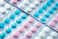 Texture of colorful tablets in blisters, heap of pills. Treatment concept from illness. Medications close-up, round antibiotics