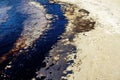 Texture of crude oil spill on sand beach from oil spill accident, Agios Kosmas bay, Athens, Greece, September 14 2017.