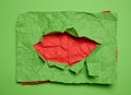 Texture of crumpled green paper with torn hole and red background Royalty Free Stock Photo