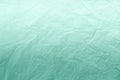 Texture of crumpled green wrapping paper with white gradient, closeup. Light cyan old background Royalty Free Stock Photo