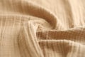 Texture of crumpled linen fabric under natural light in peach fuzz color