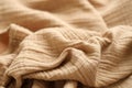 Texture of crumpled linen fabric under natural light in peach fuzz color