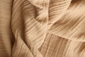 Texture of crumpled linen fabric under natural light in peach fuzz color