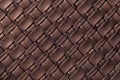 Texture of dark brown leather background with wicker pattern, macro