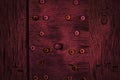 Texture of dark burgundy wood with old tapping screws. Texture of old dried plywood. Mahogany background Royalty Free Stock Photo