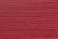 Texture of dark red old decorative panel, plastic material with wooden pattern, macro background