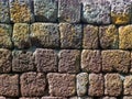 Texture of dark shade of brown and yellow rough ancient stone wall in the sunlight Royalty Free Stock Photo