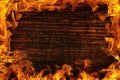 Texture of dark wood and frame out of the fire. Wood brown texture around the burning bright flame. Background of old panels.