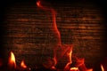 Texture of dark wood and frame out of the fire. Wood brown texture around the burning bright flame. Background of old panels. Royalty Free Stock Photo