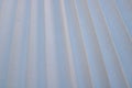 Texture of diagonal stripes with a shadow, with triangular curved ribs, edges of light white fabric, paper with triangular strips