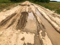 Texture of a dirty bad dirt road dirt road with puddles and clay drying mud with cracks and ruts. Off-road. The background Royalty Free Stock Photo