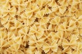 Texture of dry Italian pasta macaroni bows farfalle. Close up. Background carbohydrates food Royalty Free Stock Photo