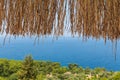 Texture of dry straw on the roof of view with a blue sea background. holiday background Royalty Free Stock Photo