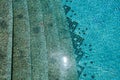 The texture of the entrance of the descent into the pool with blue water and square ceramic tiles on the steps. The background Royalty Free Stock Photo