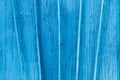 Texture exfoliating cracked blue paint. Vintage wooden background with vertical iron bars, with blue paint.