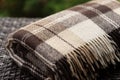 The texture of the fabric of a warm woolen brown beige checkered plaid with fringes. Royalty Free Stock Photo