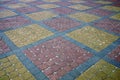 Texture of a fragment of a square old paving slab on the road