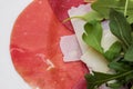 Texture of fresh sliced meat with salad. Carpaccio with parmesan cheese and arugula.