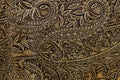 Texture of golden brown genuine leather close-up, with embossed floral trend pattern, wallpaper or banner design