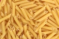 Texture of golden brown pasta in the form of pipes for cooking lunch