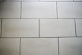 Texture of gray-brown ceramic large tiles in the form of bricks, boards with black, fouled seams located horizontally.