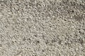 The texture of a gray cement wall interspersed with white marble chips