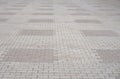 Texture of gray and yellow patterned paving tiles on the ground of street, perspective view. Cement brick squared stone floor back Royalty Free Stock Photo