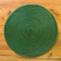 Texture of green plastic woven placemat on dining table