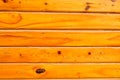 Texture of horizontal orange wooden lacquered boards with knots, handmade. The background