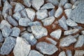 The texture of large rubble with dry yellowed needles between stones close-up