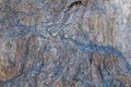 Texture of a large solid stone with a relief gray-brown pattern with chips and protrusions, veins and swellings Royalty Free Stock Photo