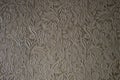 Texture of light brown wallpaper with a floral glossy pattern. Structured paper