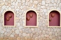 Texture light structure yellow wall cracks of natural sand stone, stone bricks three windows flower pots Arabic stylebackground Royalty Free Stock Photo