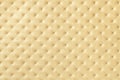 Texture of light yellow and golden leather background with capitone pattern