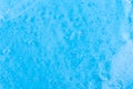 The texture of a liquid transparent gel for face cleansing. Sample of oil serum with bubbles on a blue background. Moisturizing Royalty Free Stock Photo