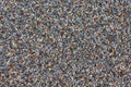 Texture of lots of small colorful pebbles on the ground.