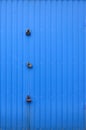 Texture of a metal blue wall with a gate closed for three locks Royalty Free Stock Photo