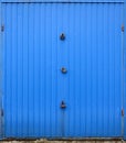 Texture of a metal blue wall with a gate closed for three locks Royalty Free Stock Photo