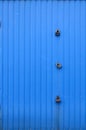 Texture of a metal blue wall with a gate closed for three locks Royalty Free Stock Photo