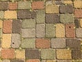 Texture of multicolored beautiful rectangular stone concrete paving brick tiles with seams overgrown with green grass. background Royalty Free Stock Photo